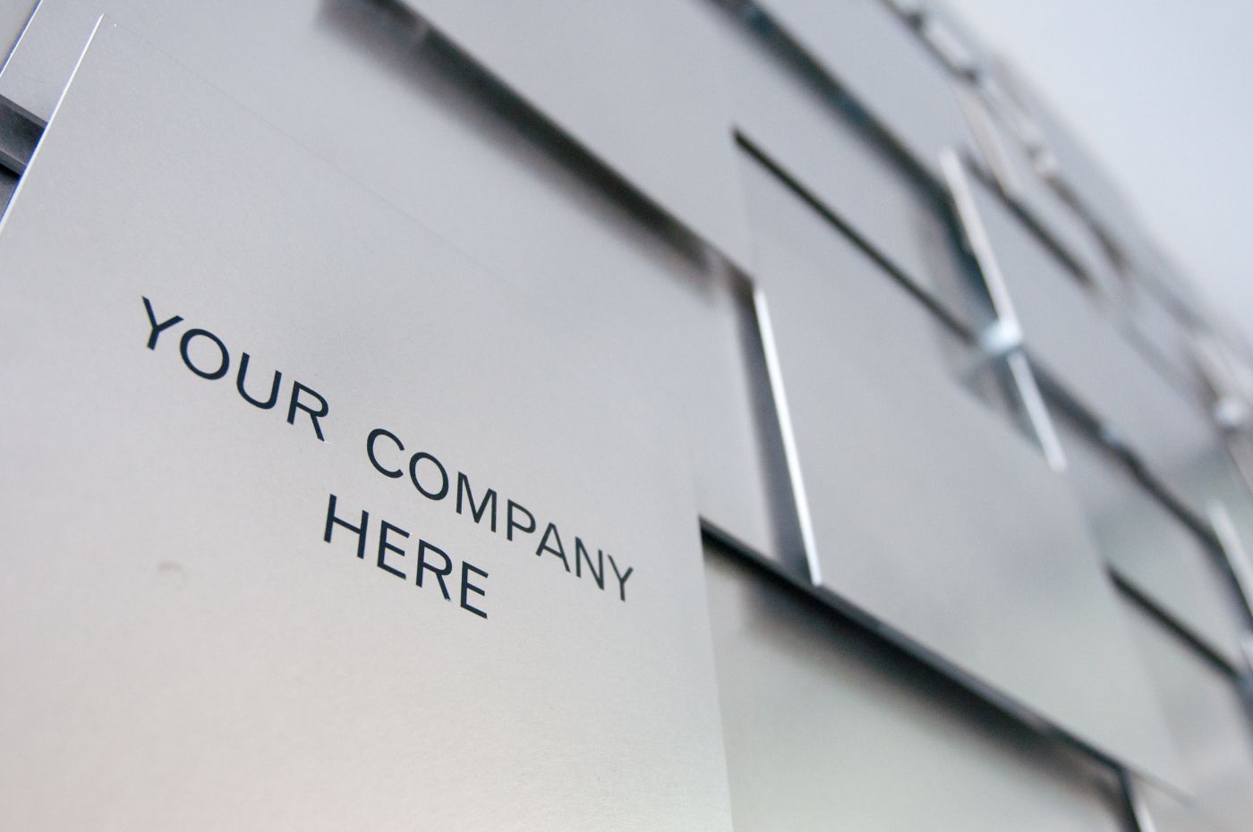 Custom commercial metal signage panels mounted on modern office building exterior